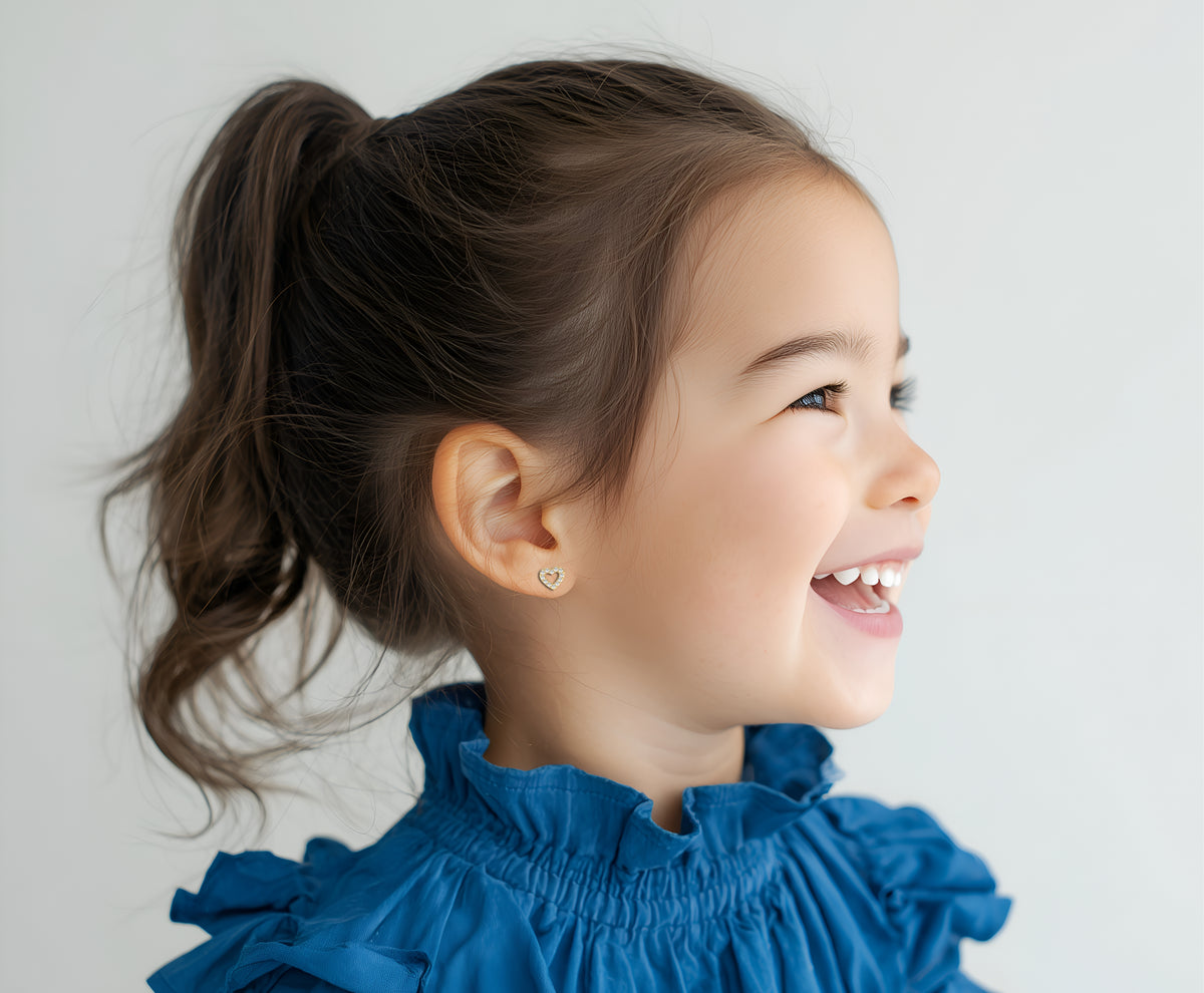 Child wearing All My Love, Clear Pavé CZ Stud Earrings in Yellow Gold with screwback post.