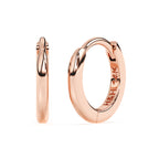 Huggie hoop earrings in rose gold.