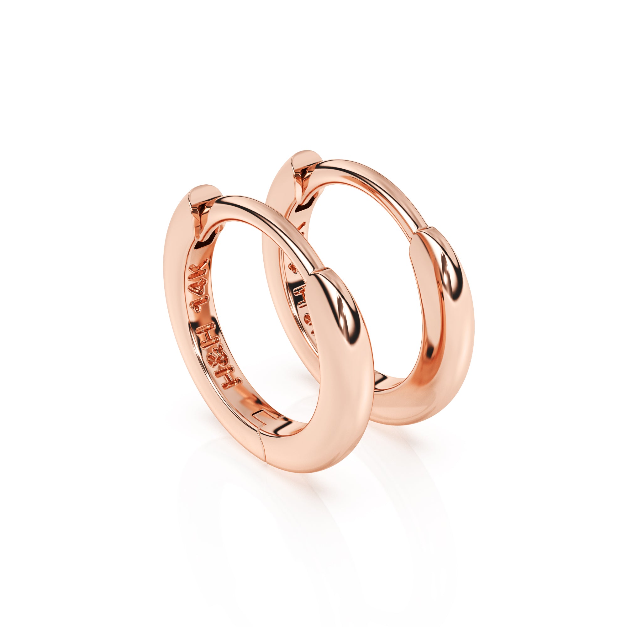 Huggie hoop earrings in rose gold.