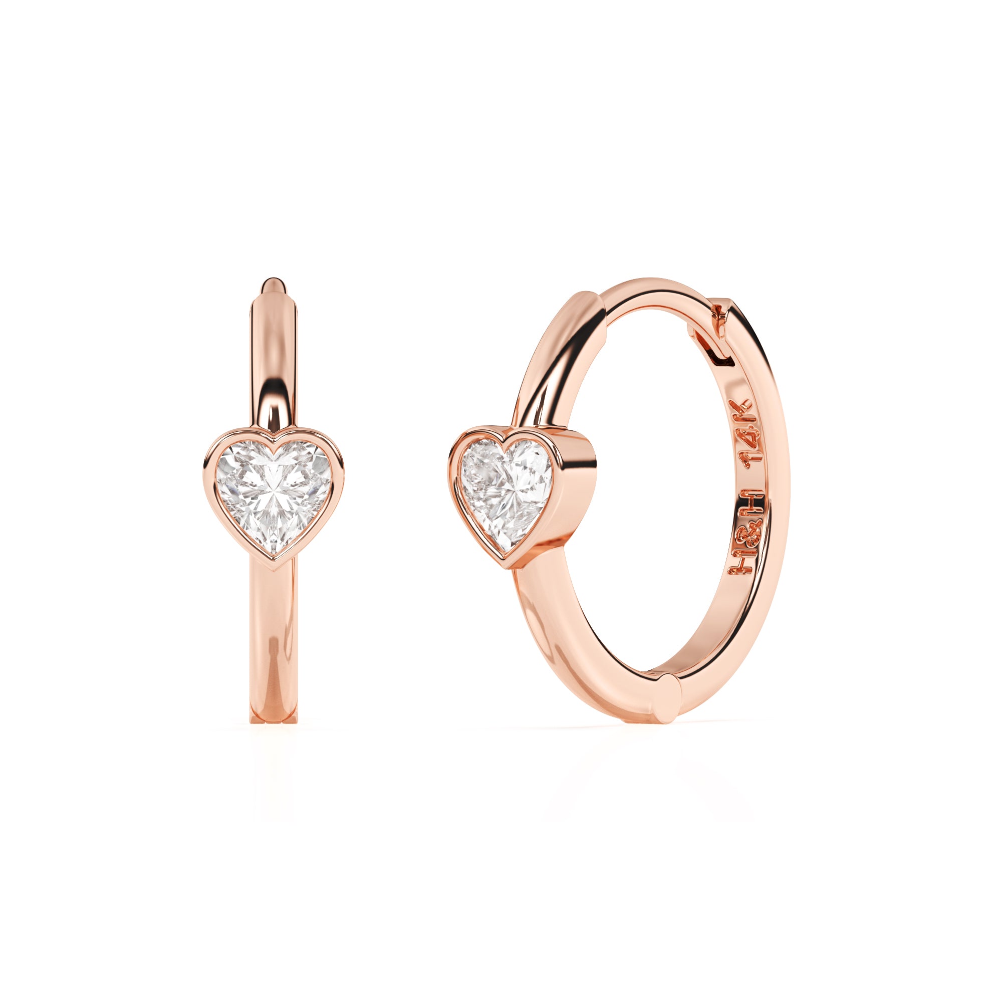 Rose gold huggie hoop earrings with a clear heart shaped stone.