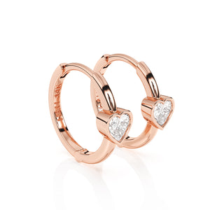 Rose gold huggie hoop earrings with a clear heart shaped stone.