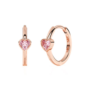 Rose gold huggie hoop earrings with a pink heart shaped stone.