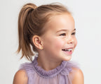 Child wearing Shining Love, Puff Heart Clear CZ Stud Earrings in Yellow Gold with screwback post.
