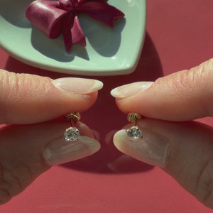 Video of 4mm clear round CZ stud earrings in solid 14K yellow gold held in hand to show their actual size for babies and children.