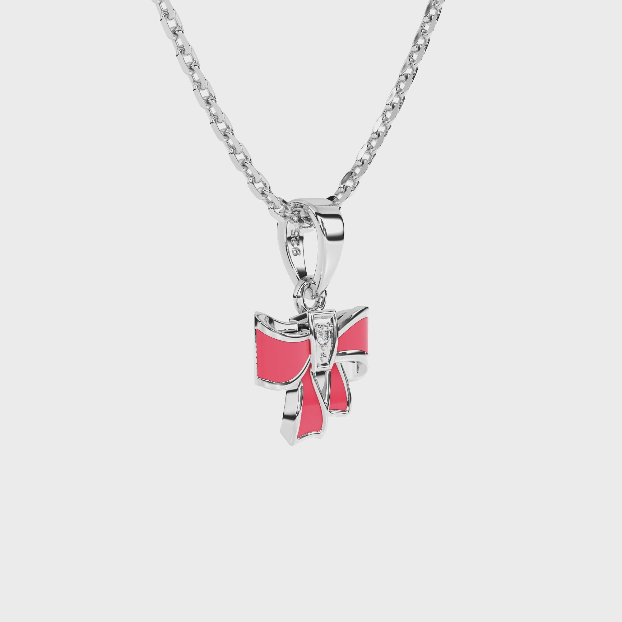 Sterling silver necklace with a pink bow pendant with clear CZ stone on a white background video.