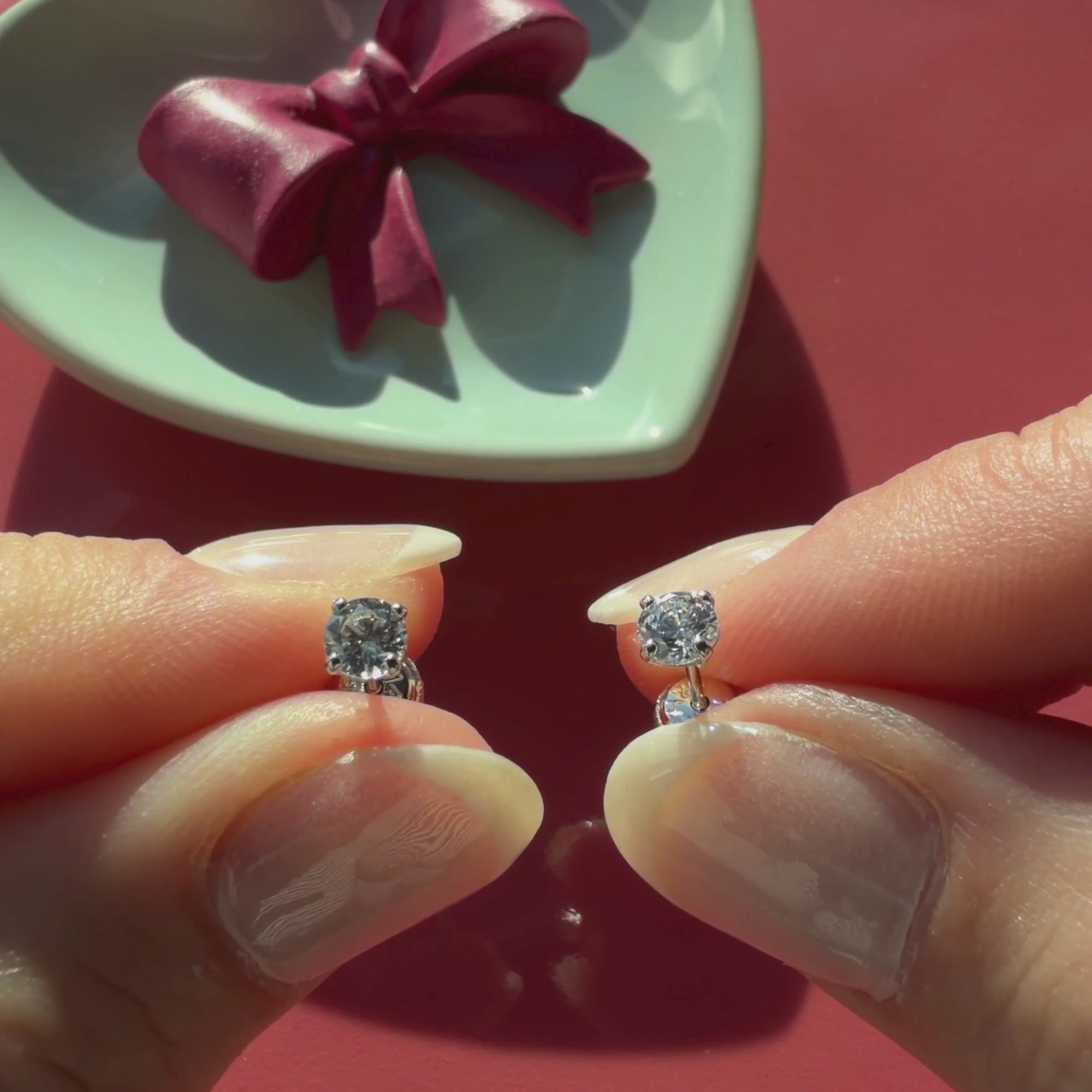 Video of 4mm clear round CZ stud earrings in solid 14K white gold held in hand to show their actual size for babies and children.