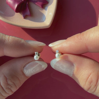 Video of 3mm pearl drop clear CZ stud earrings in solid 14K yellow gold held in hand to show their actual size for babies and children.