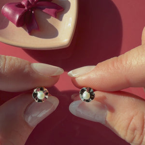 Video of Ruffled Petals and Pearls AAA-pearl stud earrings in solid 14K yellow gold held in hand to show their actual size for babies and children.