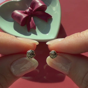 Video of Blooming Rose clear CZ stud earrings in solid 14K yellow gold held in hand to show their actual size for babies and children.