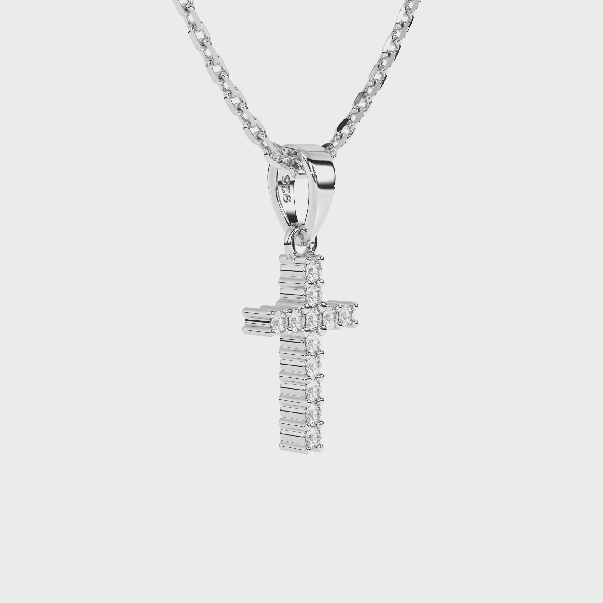 Sterling silver cross pendant with clear pave set CZ necklace on a white background video.