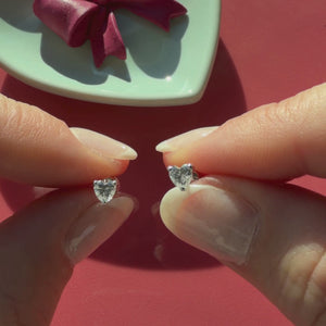 Video of 4mm clear heart CZ stud earrings in solid 14K white gold held in hand to show their actual size for babies and children.