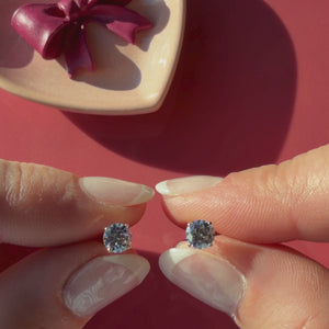 Video of 5mm clear round CZ stud earrings in solid 14K yellow gold held in hand to show their actual size for babies and children.