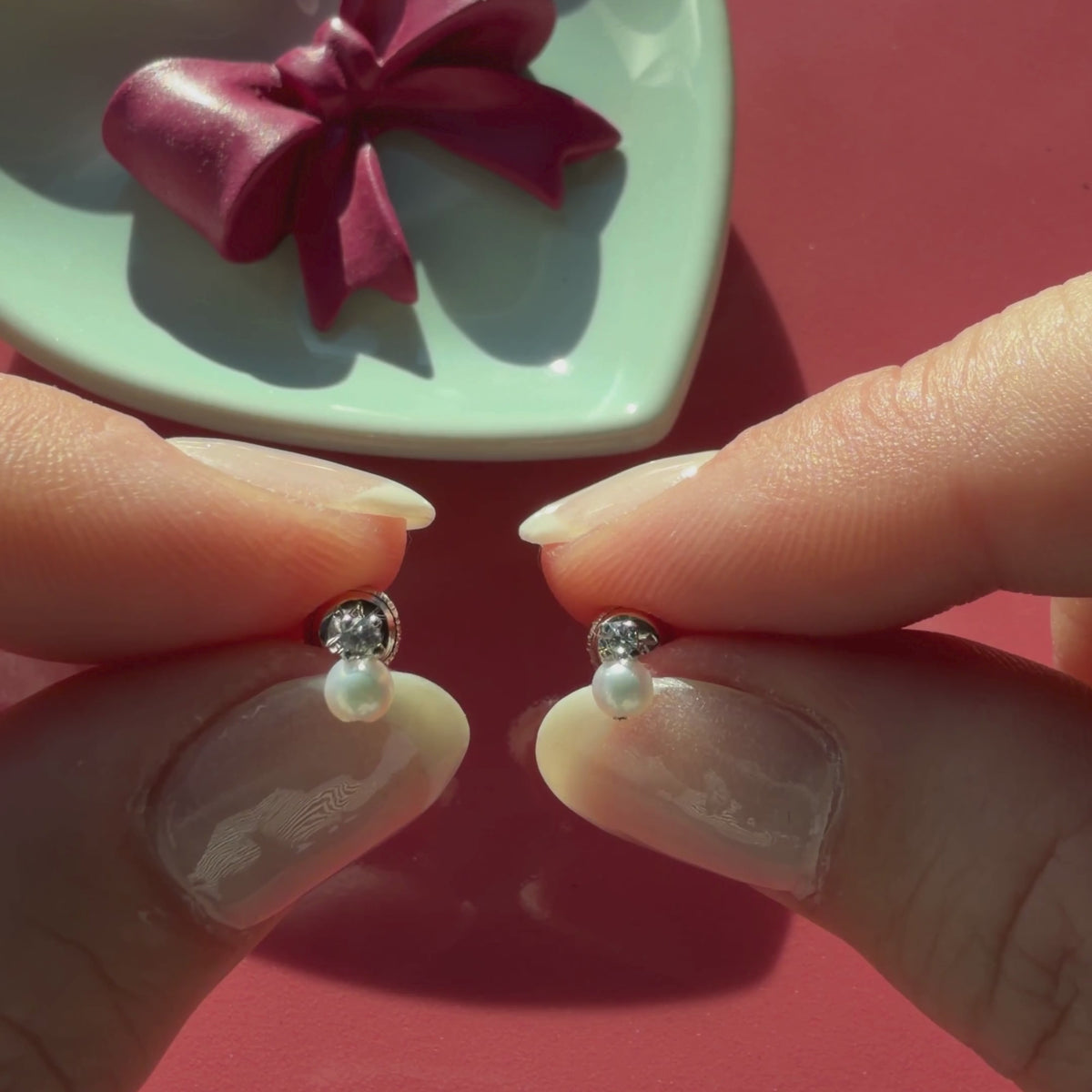 Video of 3mm pearl drop clear CZ stud earrings in solid 14K white gold held in hand to show their actual size for babies and children.