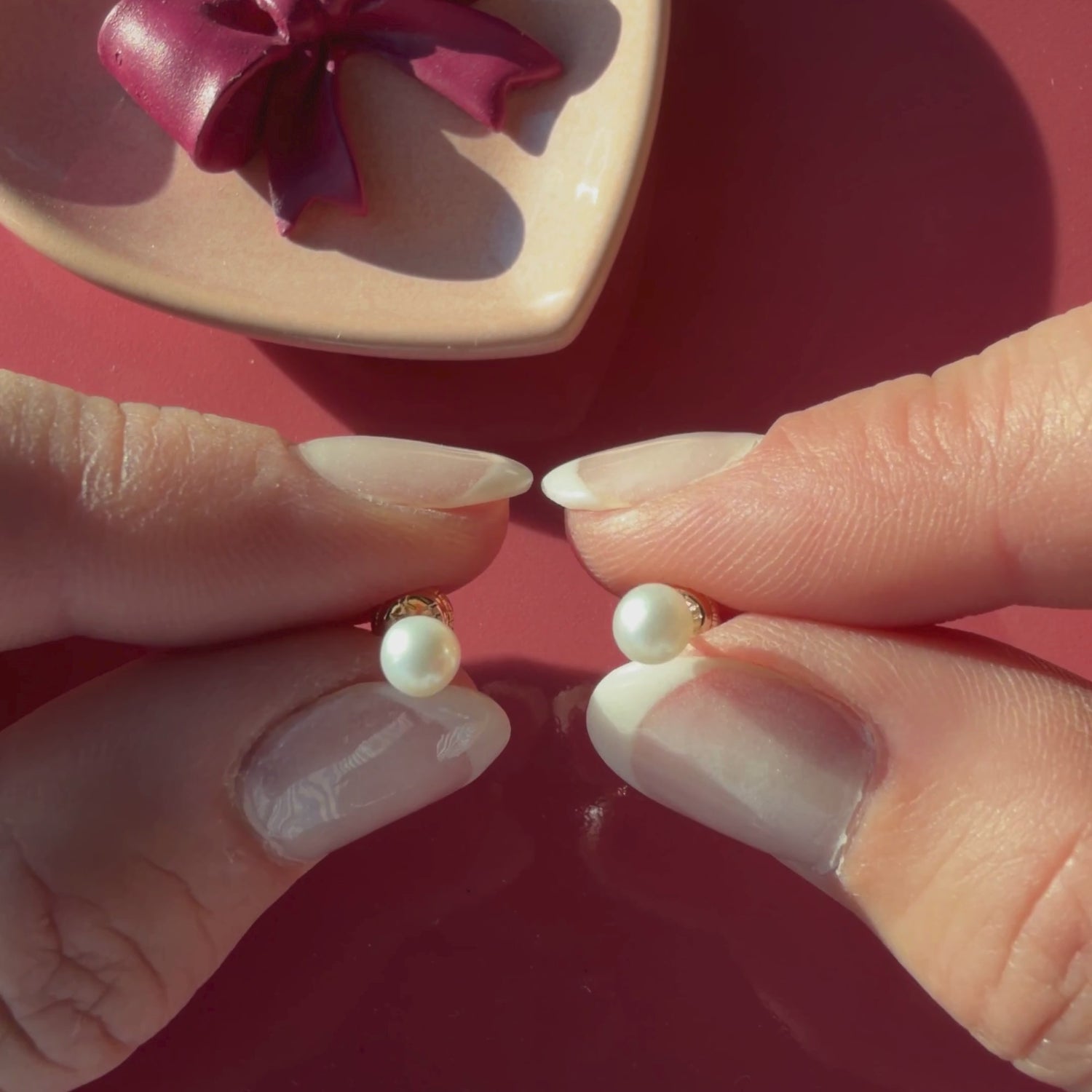 Video of 4mm pearl stud earrings in solid 14K yellow gold held in hand to show their actual size for babies and children.