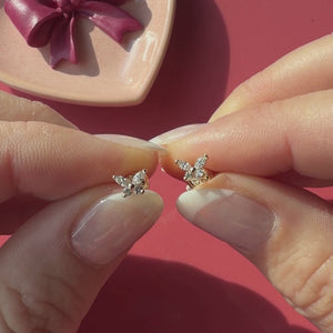 Video of Brilliant Butterfly clear CZ stud earrings in solid 14K yellow gold held in hand to show their actual size for babies and children.