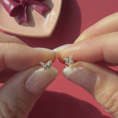 Video of Brilliant Butterfly clear CZ stud earrings in solid 14K yellow gold held in hand to show their actual size for babies and children.