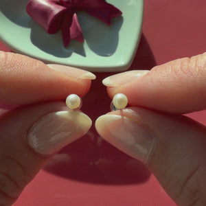 Video of 3mm pearl stud earrings in solid 14K white gold held in hand to show their actual size for babies and children.