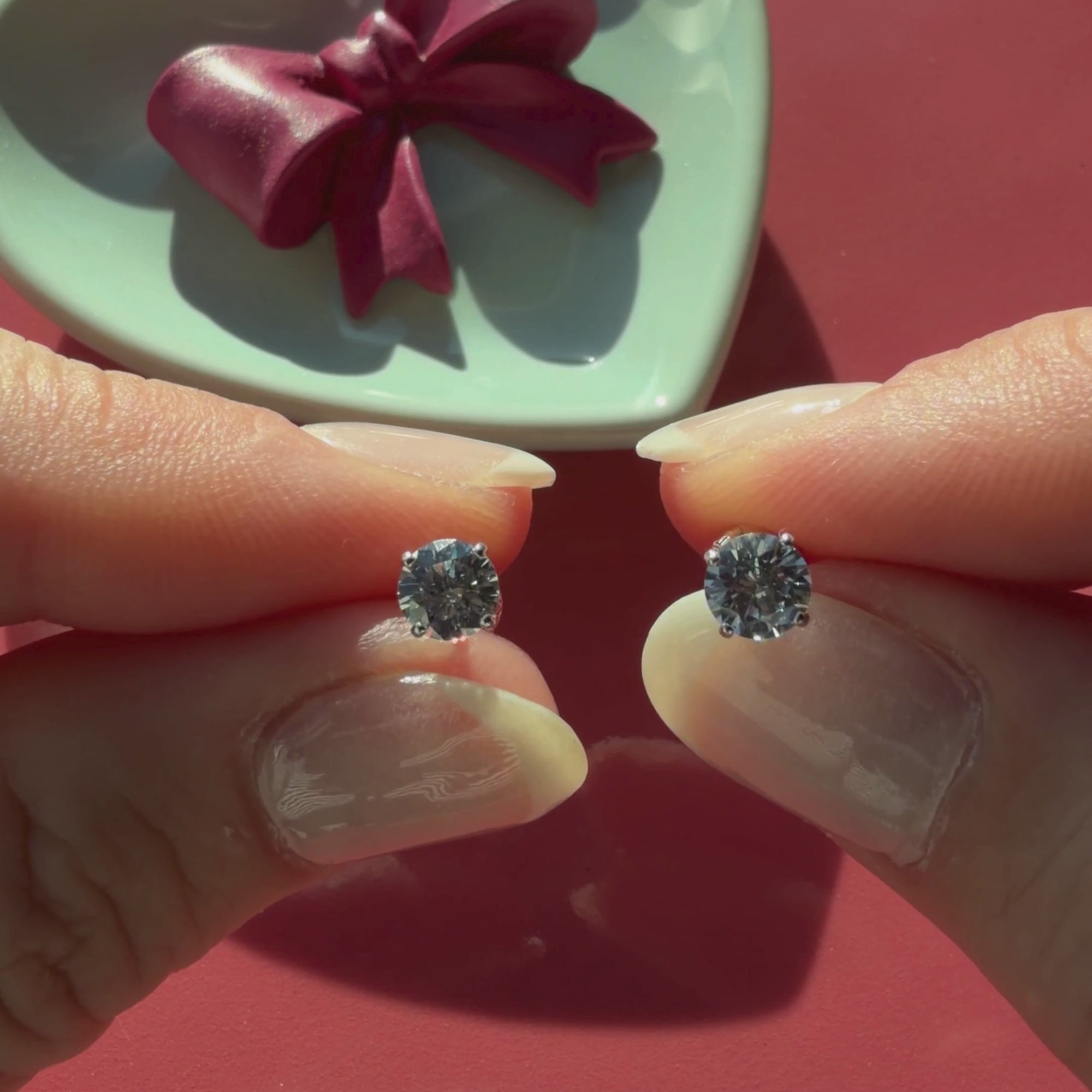 Video of 5mm clear round CZ stud earrings in solid 14K white gold held in hand to show their actual size for babies and children.