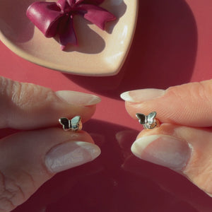 Video of Petite Butterfly stud earrings in solid 14K yellow gold held in hand to show their actual size for babies and children.