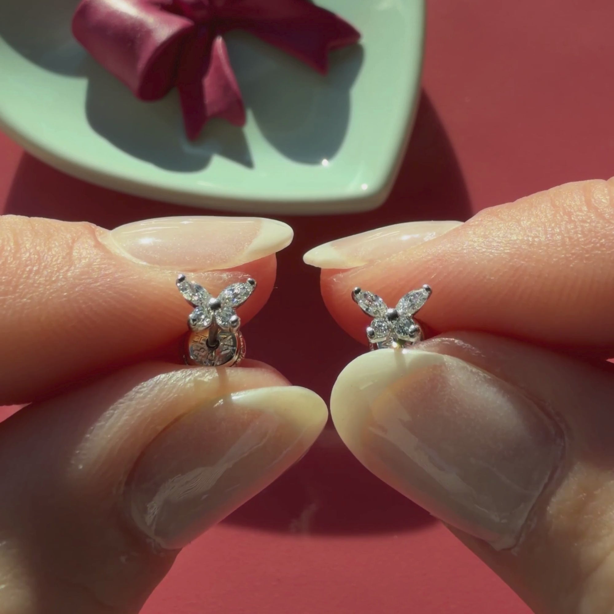 Video of Brilliant Butterfly clear CZ stud earrings in solid 14K white gold held in hand to show their actual size for babies and children.