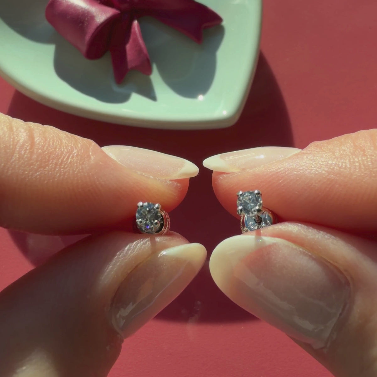 Video of 3mm clear round CZ stud earrings in solid 14K white gold held in hand to show their actual size for babies and children.
