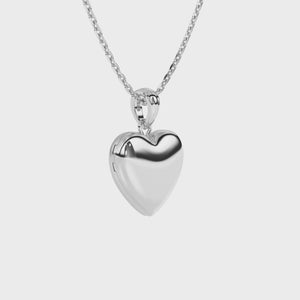 Sterling silver heart locket pendant on a white background video.