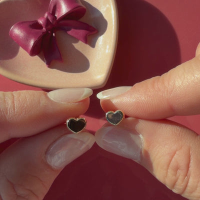 Video of Elegant Heart stud earrings in solid 14K yellow gold held in hand to show their actual size for babies and children.