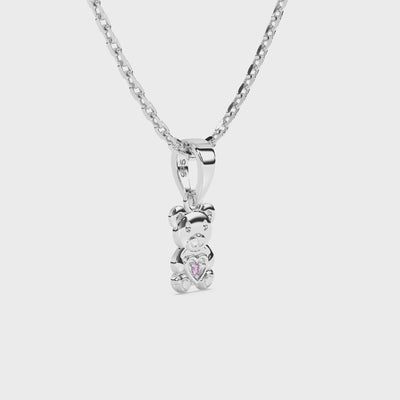 Sterling silver teddy bear pendant necklace with pink CZ stone on a white background video.